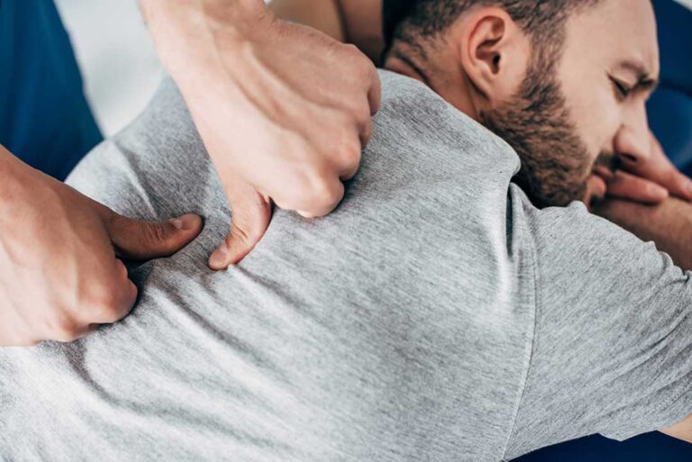 A chiropractor assessing the posture of a young athlete in a clinic setting.