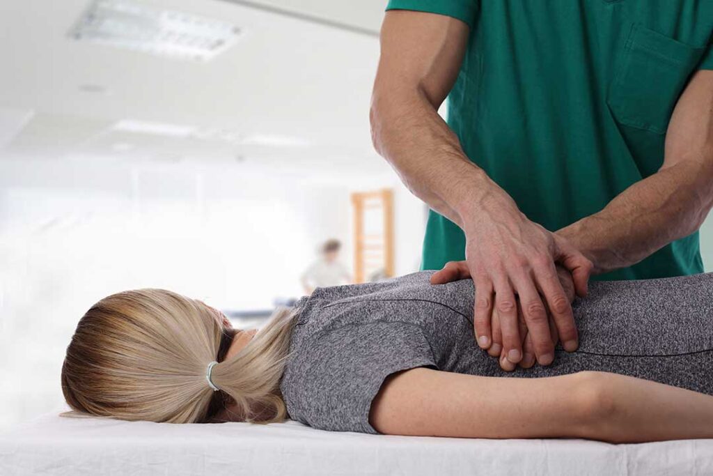 Person with chronic back pain lying on their side with a pillow between their knees