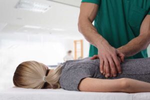Person with chronic back pain lying on their side with a pillow between their knees