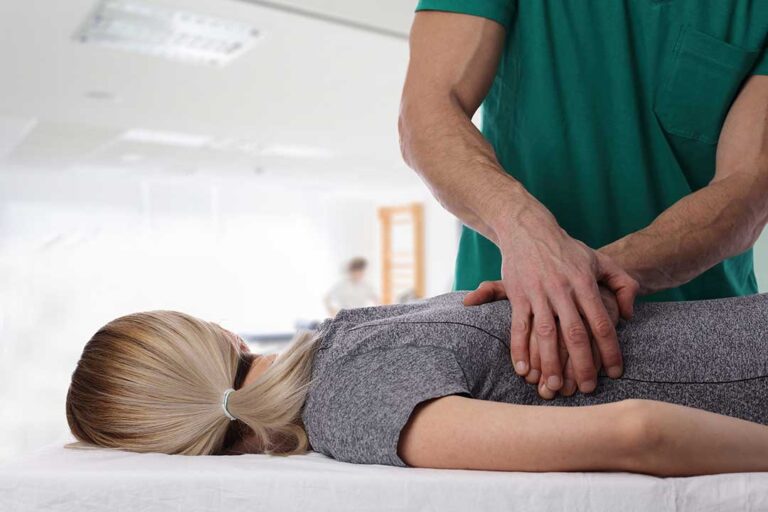Person with chronic back pain lying on their side with a pillow between their knees